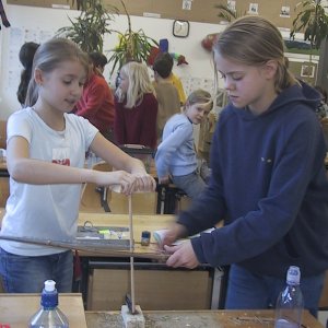 Zwei Kinder reiben
                        Feuer mit Pfl�cken, Stab und Pfeilbogen
                        rundherum, und der Stab wird sehr, sehr heiss