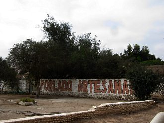 Ein Graffiti k�ndigte das
                            Kunsthandwerkerdorf an ("Poblado
                            artesanal")
