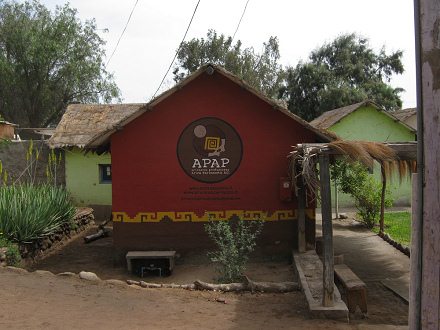 Kunsthandwerkerdorf von Arica, mit dem
                            Logo der APAP und mit mit Webseite und
                            E-Mail an der Hausfassade
