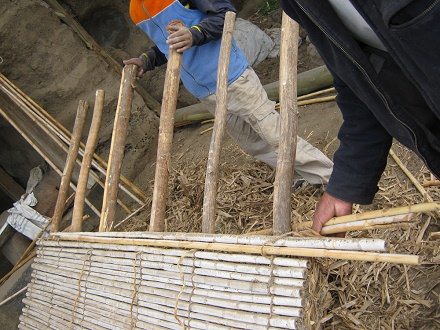 Die Schilfrohr-Strohwand wird
                                  weitergeflochten