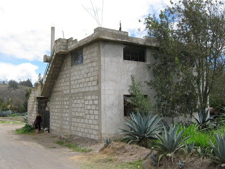 Haus im Bau und Frau mit goldfarbenem
                          Dorfhut