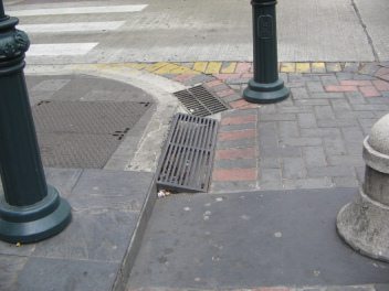 Centro de Guayaquil, rampa de acera en
                          reja de metal, y sumidero con reja estrecha