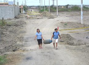 Aduana ecuatoriana, dos ecuatorianas
                          transportando una bombona de gas, primer
                          plano