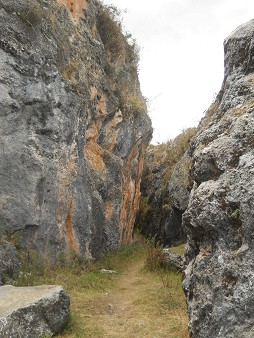 Cusco Sacsayhuam�n, Zone X (Laq'o, Laco, Mondtempel), der Weg f�hrt an geschnittenen, schwarz-roten Felsen vorbei