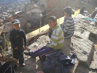 Cusco Sacsayhuam�n 16: Der Weg zur�ck nach Cusco, Bev�lkerung von Cusco sitzt auf der aus dem Felsen geschnittenen Sitzbank