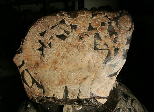 Dinosaurier (Mischung aus Stegosaurus
                            und Camarasaurus oder Brontosaurus) mit
                            einem Weisen mit Beil und Echse