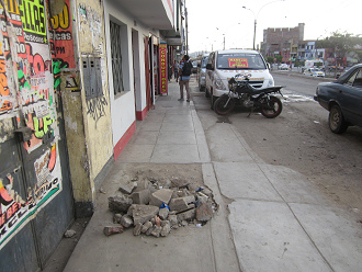 Hueco
              gigante en la acera de la avenida Tupac Am�ru en Comas
              llenado con derrumbe as� NADIE puede pasar
