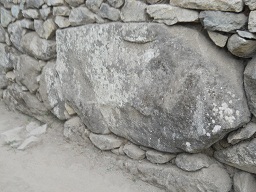 Zwischen dem Weiler mit dem heiligen Stein und den Arbeitsh�usern: Ein grosser Stein in der Mauer