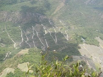 Machu Picchu, Sicht vom Weiler Huaynapicchu auf die Serpentinenstrasse, die von der Ortschaft Aguas Calientes (Heisse Wasser) nach Machu Picchu heraufkommt 04