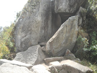 Sicht auf den Gipfel von Huaynapicchu mit dem Steinbruch mit geschnittenen Gigasteinen, die einen zweiten Tunnel bilden 02