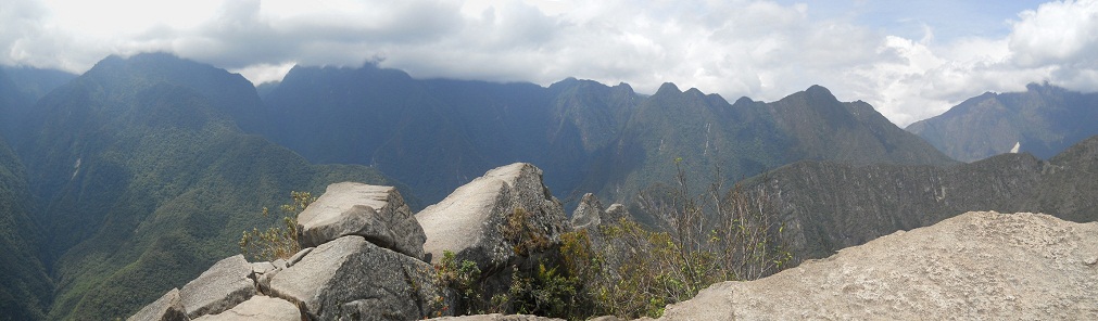 Der Berggipfel von Huaynapicchu, ein Steinbruch mit geschnittenen Gigasteinen auf dem Gipfel, Sicht auf die Berge, Panoramafoto