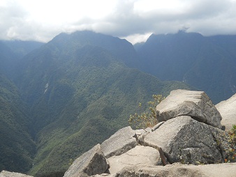 Der Berggipfel von Huaynapicchu, ein Steinbruch mit geschnittenen Gigasteinen auf dem Gipfel, Sicht auf die Berge 01
