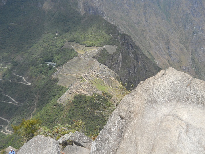 Machu Picchu, Hausberg Huaynapicchu, geschnittene Gigasteine auf dem Gipfel und die Aussicht auf Machu Picchu