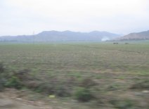 Panamericana, Ebene von Barranca-Paramonga,
                        Feld mit W�stenbergen und M�llverbrennung (01)