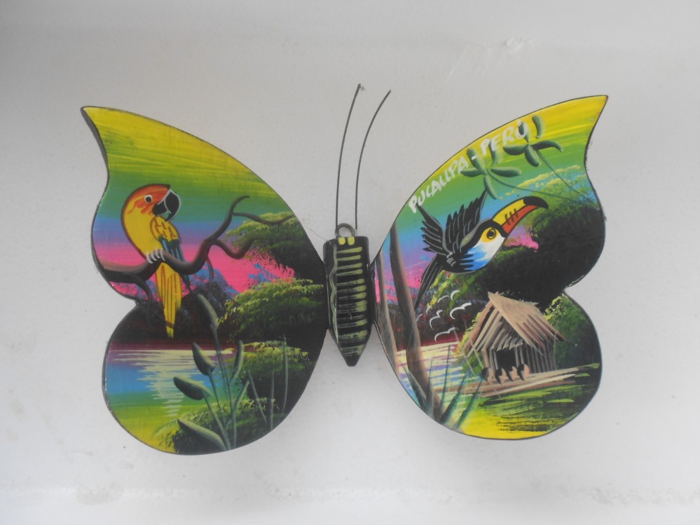 Mariposa grande en
                        madera, pintada a mano por nativos Shipibos,
                        regi�n de Pucallpa (Per�), verde con loro y
                        tuc�n