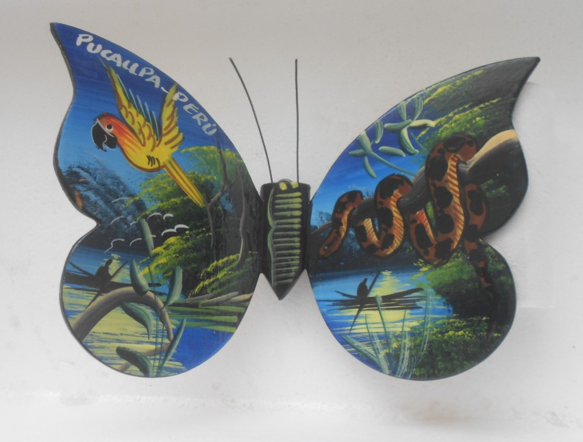 Mariposa
                        grande en madera, pintada a mano por nativos
                        Shipibos, regi�n de Pucallpa (Per�), celeste con
                        loro y serpiente boa